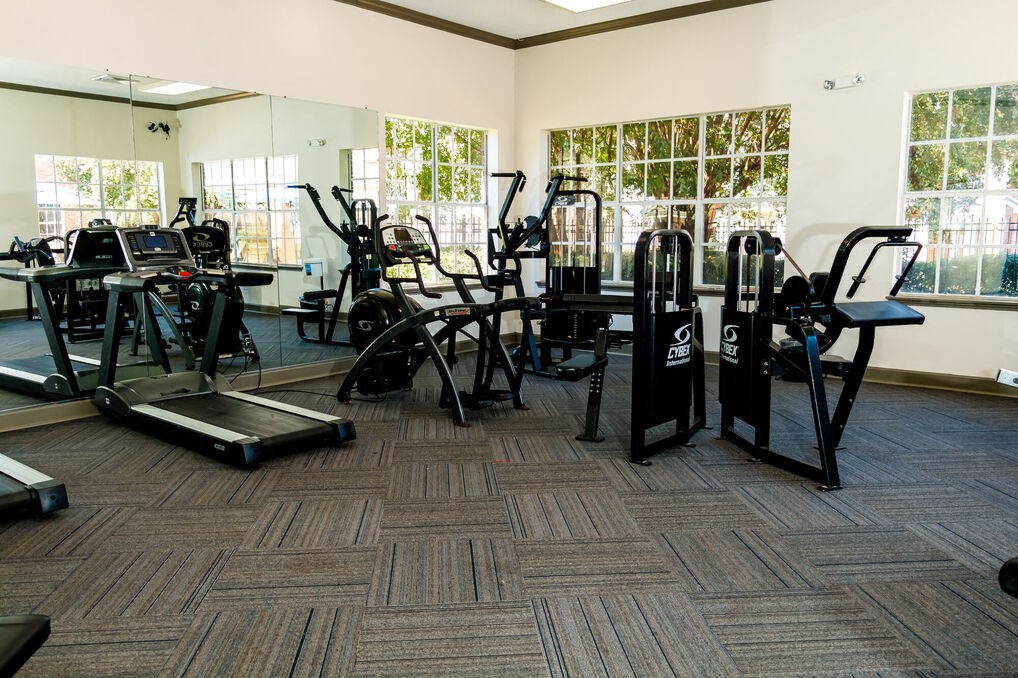 a gym with cardio equipment and weights in a building