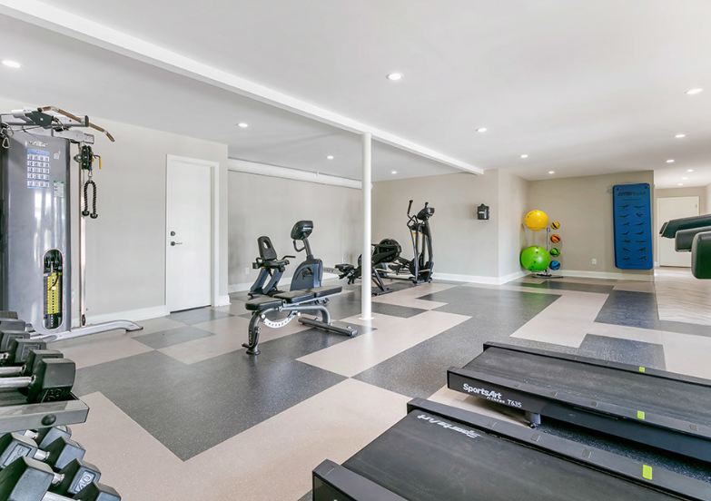 a gym with treadmills and weights on a checkered floor