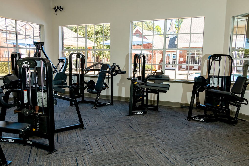 a gym with cardio equipment and windows in a building