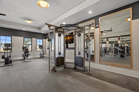 A gym with a variety of equipment including a treadmill, weights, and a bench press.