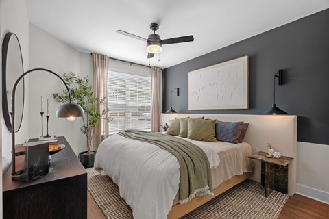 A bedroom with a large bed and a ceiling fan.