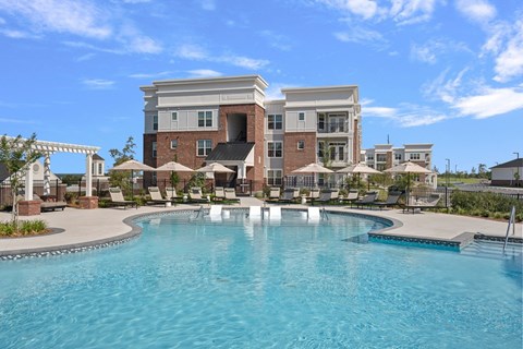 A large swimming pool in front of a multi-story building.
