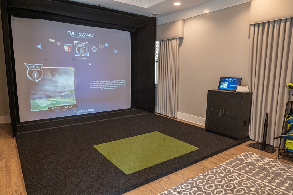 A projection screen in a room with a green mat on the floor.