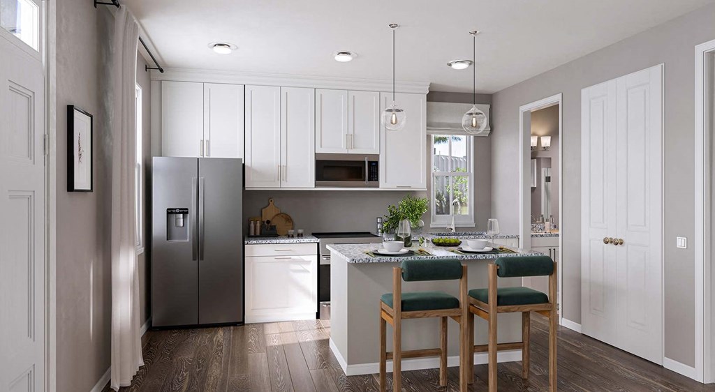 A kitchen with a table and chairs in front of it.