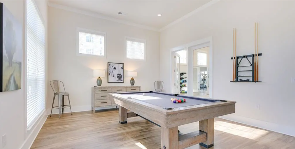 a large white room with a pool table in the middle of it