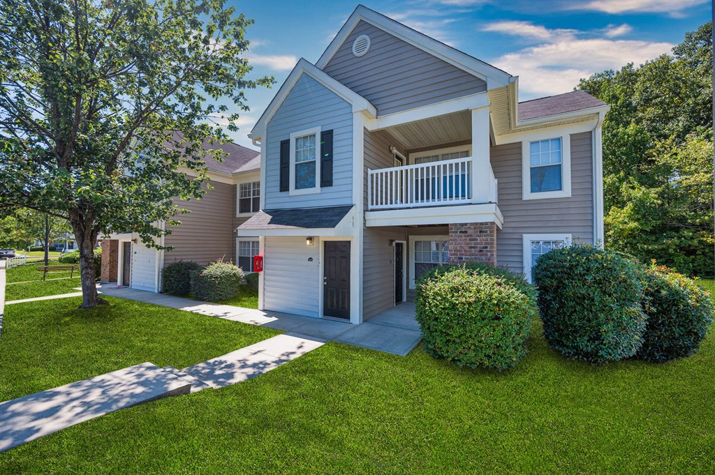 a white and gray house with a porch and a sidewalk