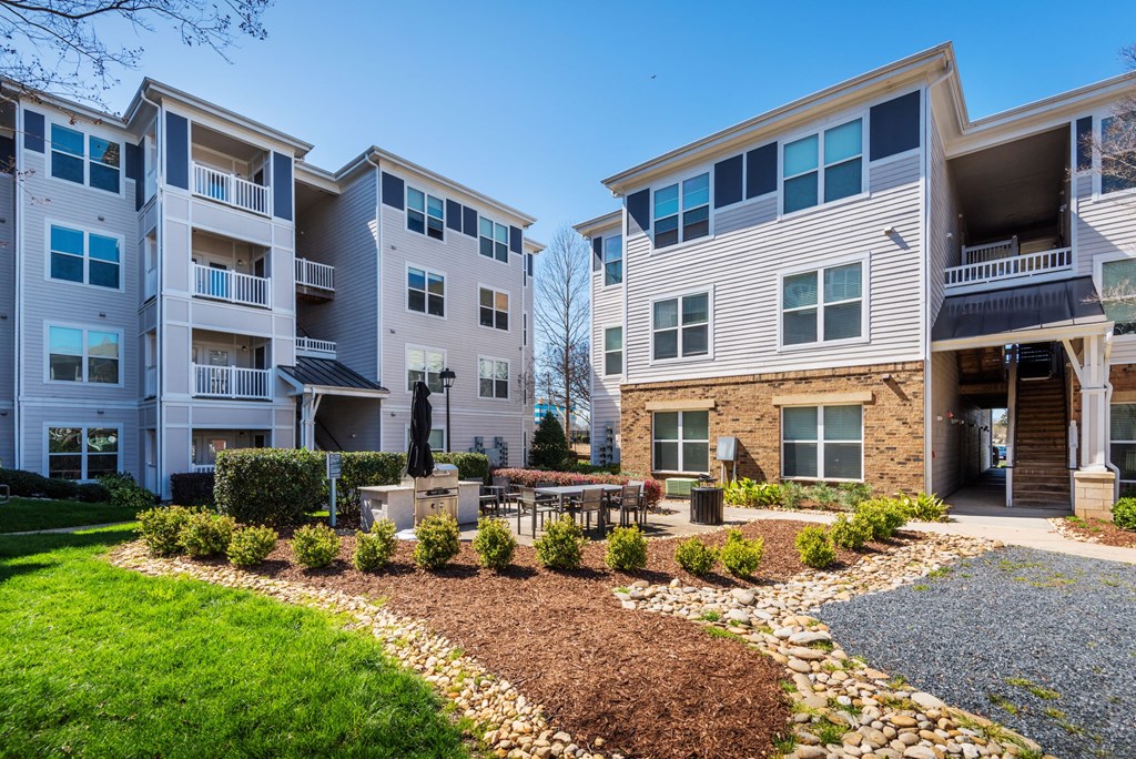 an exterior view of an apartment building with a landscaped courtyard