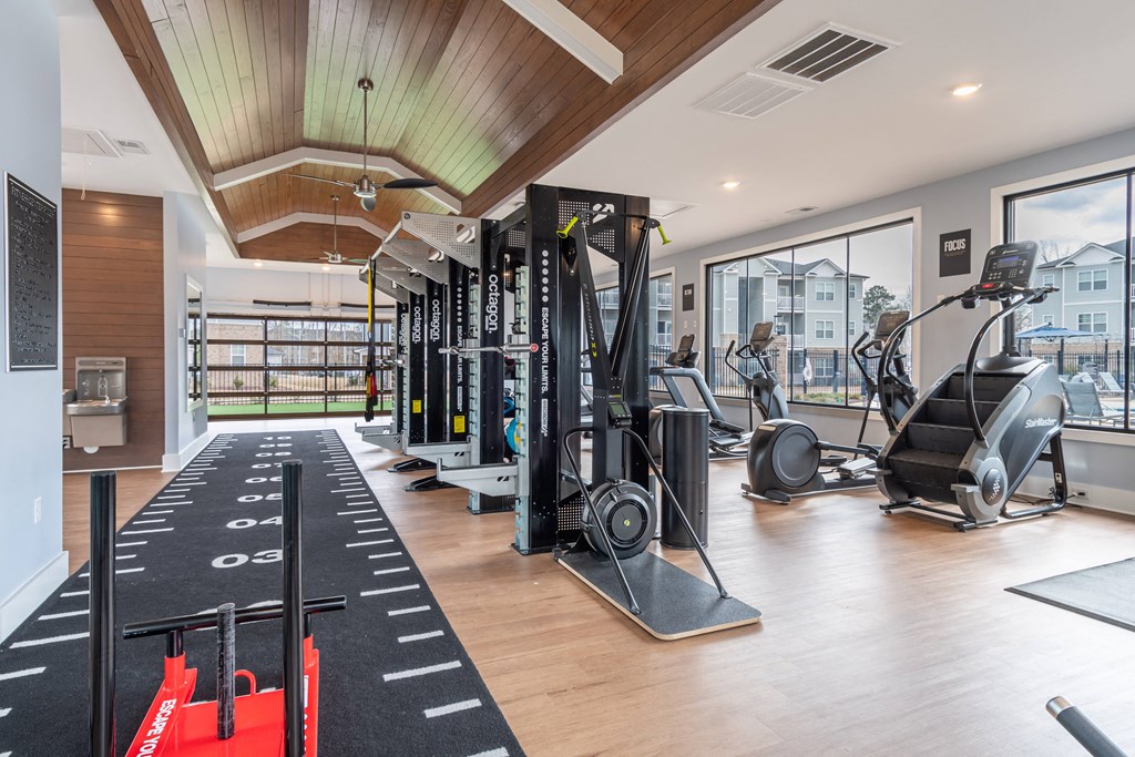 a gym with weights and cardio equipment and a view of a building