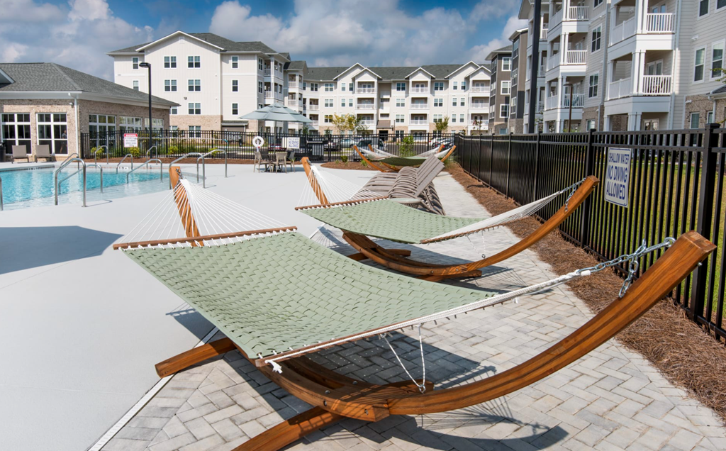 a row of hammocks on a patio next to a pool