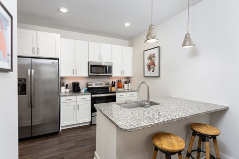 A kitchen with a granite countertop and stainless steel appliances.