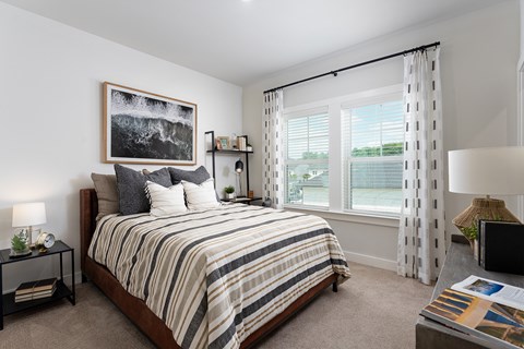 A bedroom with a large bed and a painting on the wall.