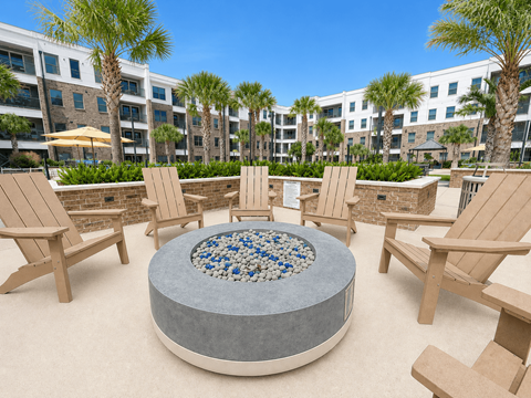 A round table with a mosaic top is surrounded by chairs in a courtyard.