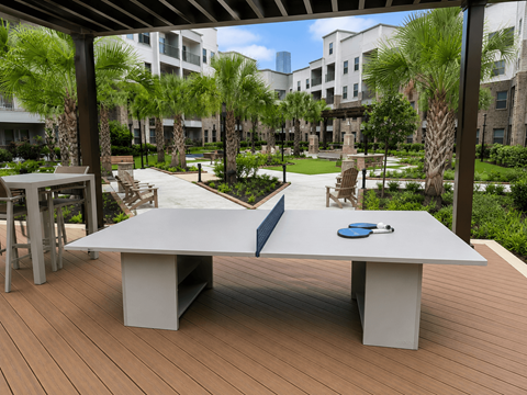 A white table with a blue cloth on it is in the foreground of a wooden deck.