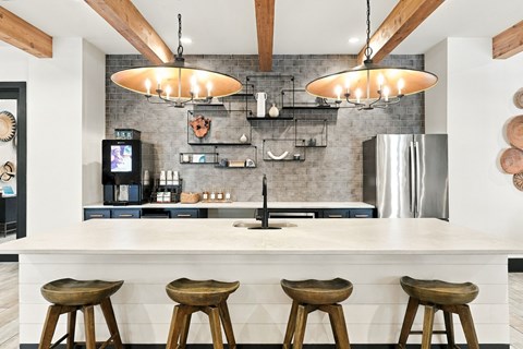 A kitchen with a white counter and wooden stools.