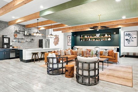 A modern living room with a kitchen area in the background.