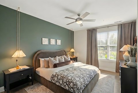 A bedroom with a large bed and a ceiling fan.