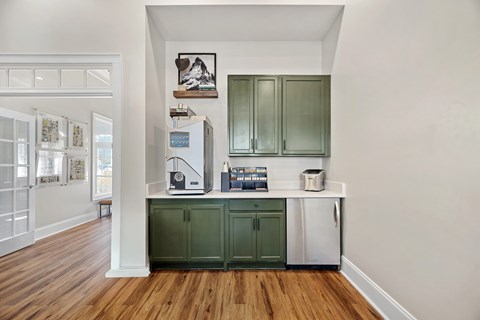 A kitchen with green cabinets and a white fridge.