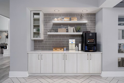 A modern kitchen with a white cabinet and a black coffee maker.