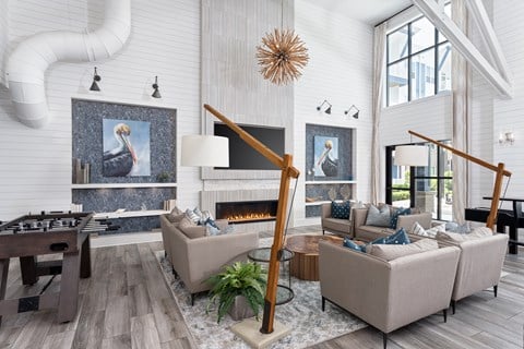 A living room with a fireplace and a painting of a bird on the wall.