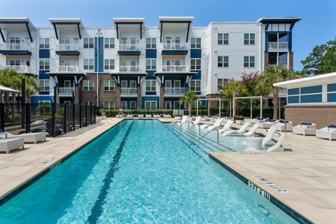 A long rectangular pool in front of apartment buildings.