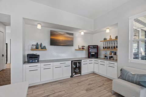 A kitchen with white cabinets and a wooden floor.