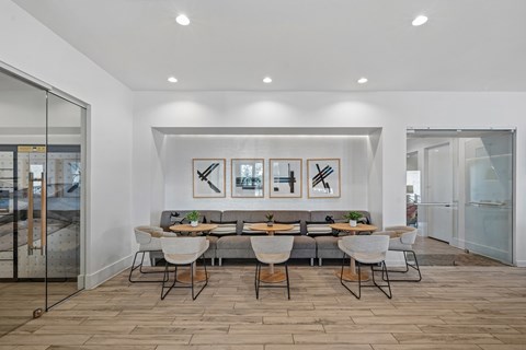 A modern dining room with a glass table and chairs.