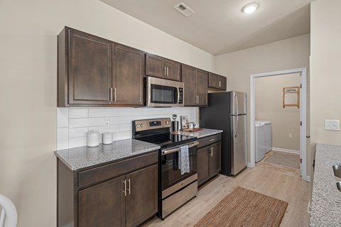A kitchen with dark brown cabinets and stainless steel appliances.