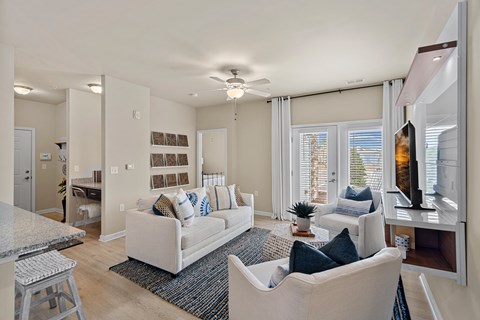 A living room with a white couch and a ceiling fan.