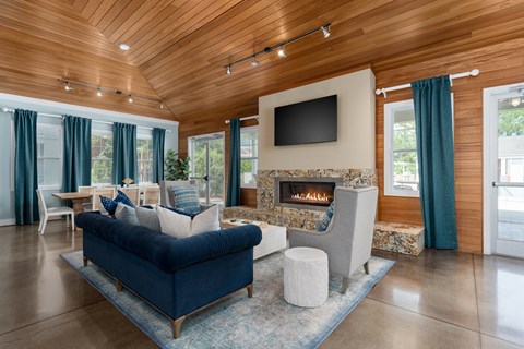 A living room with a blue couch and a fireplace.