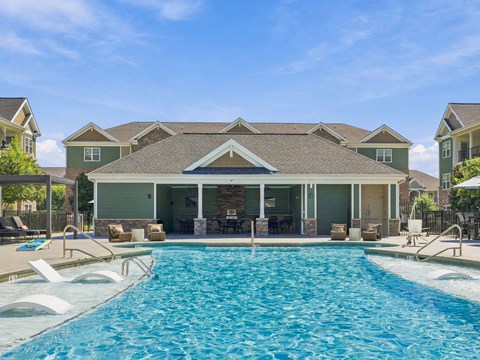 A large house with a pool in front.