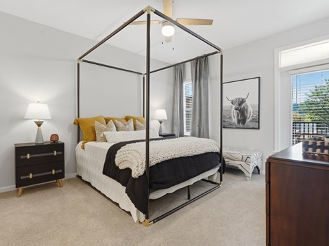 A bedroom with a four poster bed and a painting of a cow on the wall.