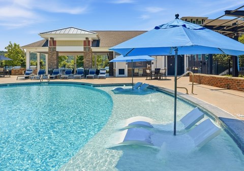 A blue umbrella is next to a pool.