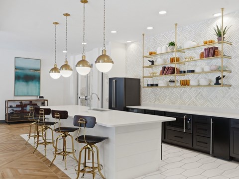 A kitchen with a white counter and black bar stools.