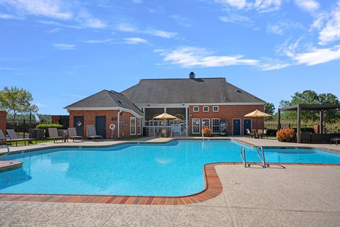 A large swimming pool in front of a house.