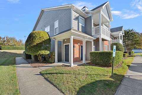 A house with a grey and white exterior and a brown door.