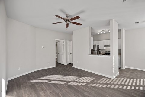 A room with a ceiling fan and a large rug on the floor.