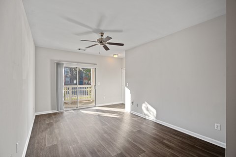 A room with a ceiling fan and a door leading outside.