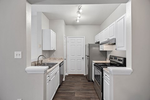 A kitchen with white cabinets and a black stove top oven.