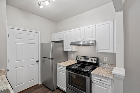 A kitchen with white cabinets and stainless steel appliances.