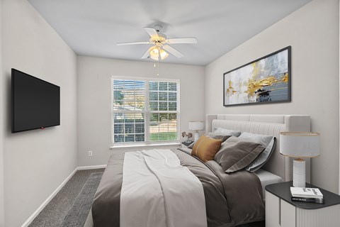 A bedroom with a bed, a ceiling fan, and a window with blinds.