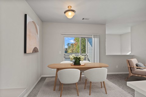 A dining room with a table and chairs.