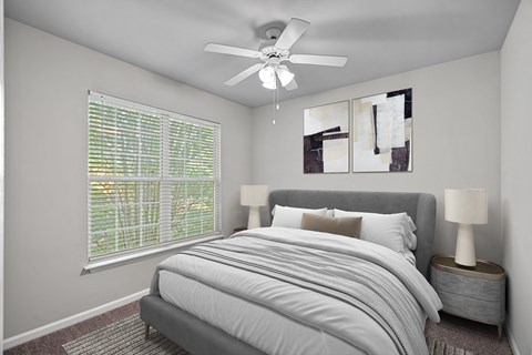 A bedroom with a large bed and a ceiling fan.