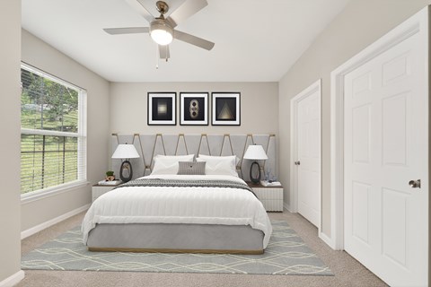 A bedroom with a large bed and a ceiling fan.