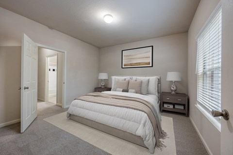 A bedroom with a large bed and a painting on the wall.
