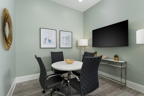 A dining room with a white table and chairs.