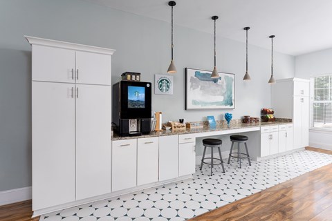 A kitchen with white cabinets and a black and white tiled floor.