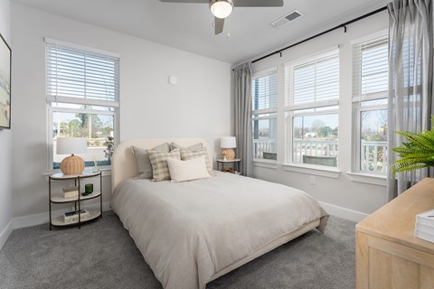 A bedroom with a large bed and a ceiling fan.