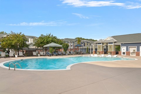 A swimming pool in a residential area with houses in the background.