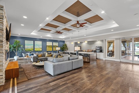 A modern living room with a grey sofa and wooden floors.