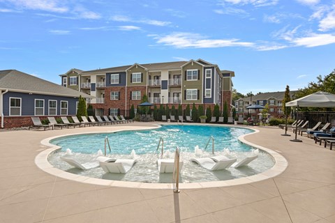 A large swimming pool with a fountain in the middle of a residential area.